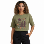 Young woman wearing a "Vale Girl" breathable cotton t-shirt with a vintage floral and hummingbird graphic design, available in Olive Green, Royal Blue, and Red.