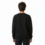 Person wearing a VALE graphic cotton sweatshirt featuring botanical leaves, acorns, and stars in Black, Forest Green, and Burnt Orange colors.