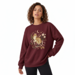 "Professional studio shot of a woman wearing a VALE brand cotton sweatshirt featuring a detailed fox and moon graphic design, available in Maroon, Forest Green, and Heather Gray."