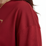 Front view of a female model wearing a VALE Nature's Legacy oversized cotton t-shirt featuring a phoenix and floral graphic design in Maroon, Blue, and White.