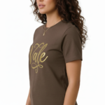 Woman wearing a breathable cotton t-shirt with "Vale" gold script calligraphy design, available in brown, olive green, and maroon.