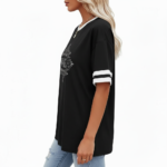 A person wearing a breathable cotton VALE graphic t-shirt with varsity stripes on sleeves, available in black, brown, and orange.