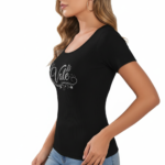 Close-up of a woman wearing a breathable ribbed cotton t-shirt featuring a glittery "Vale" graphic design with floral accents.