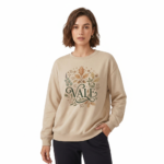 Woman wearing a VALE graphic cotton sweatshirt with autumn leaf botanical design, available in Beige, Slate Blue, and Burnt Orange.