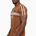 Man wearing VALE brand breathable cotton tracksuit with short-sleeve t-shirt and matching joggers in earth tones.