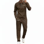 Front view of a professional male model wearing a VALE brand textured cotton tracksuit featuring a quarter-zip polo sweatshirt and matching joggers with minimalist graphic logos on the chest and thigh.