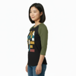 A woman wearing a breathable cotton raglan baseball shirt featuring a colorful geometric "VALE" logo and a central compass graphic. Available in Maroon, Grey, and Olive Green sleeves with a black or burgundy torso.