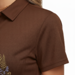 Woman wearing a VALE botanical cotton polo shirt with floral and moon phase graphic design in Earthy Brown, Forest Green, and Sand Beige colors.