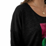 Front view of a woman wearing a breathable cotton 3/4 sleeve shirt with a "VALE" artistic watercolor geometric graphic design, available in maroon, black, and blue.