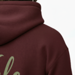 A man wearing a premium breathable cotton tracksuit featuring a sage green "Vale" script logo and olive branch graphic on the back, available in Black, Charcoal Grey, and Burgundy.