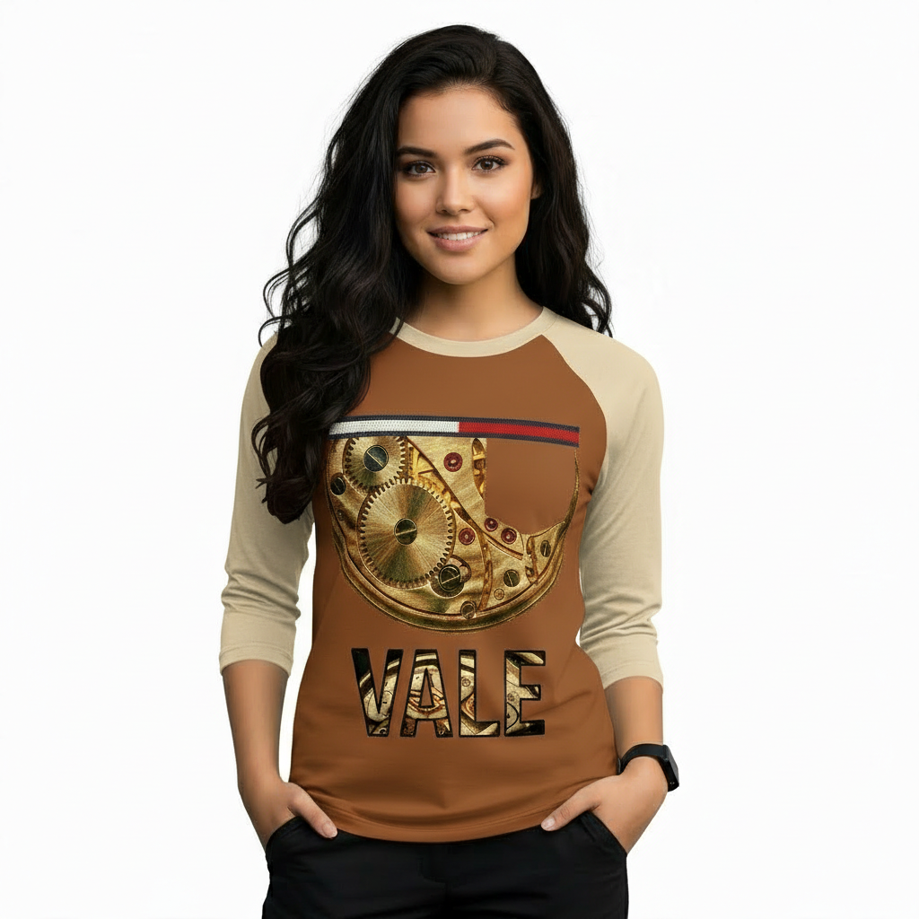Woman wearing a VALE brand raglan shirt featuring a detailed gold mechanical watch gear graphic and steampunk-style typography on breathable cotton fabric.