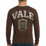 Back view of a man wearing a VALE graphic long-sleeve cotton shirt featuring a vintage gate design and Roman numerals MCMXCIX.