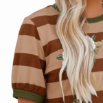 A woman wearing a breathable cotton striped t-shirt featuring a white rose wreath graphic and contrast green neckline, paired with blue denim.