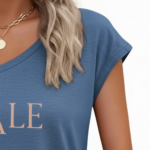 Woman wearing a breathable cotton V-neck t-shirt with "VALE" graphic print, available in Navy Blue, Slate Blue, and Olive Green.