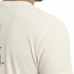 Back view of a man wearing a VALE brand 100% cotton breathable T-shirt featuring a black geometric compass and celestial line-art design.