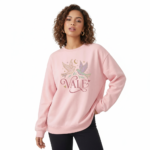 Woman wearing a VALE celestial bird graphic sweatshirt in pink, red, and cream colors. 100% breathable cotton long-sleeve shirt with moon and star design.
