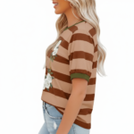 A woman wearing a breathable cotton striped t-shirt featuring a white rose wreath graphic and contrast green neckline, paired with blue denim.