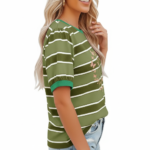 A smiling model wearing a breathable VALE brand cotton t-shirt with horizontal stripes, featuring a central butterfly graphic design and puff sleeves, paired with light-wash distressed denim jeans against a clean white background.