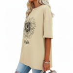Front view of a woman wearing a Vale brand oversized cotton t-shirt featuring a large black line-art sunflower graphic, available in beige, blue, and green.