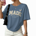 Flat lay and model view of women's oversized "MADE Pure Joy" floral graphic t-shirt in dusty brown, slate blue, and sage green.