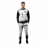 Full-body studio mockup of a man wearing a VALE brand breathable cotton tracksuit featuring a hand-passing-a-key graphic and ink-splatter design, available in grey, brown, and white-black contrast.