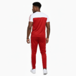 Man wearing VALE brand two-tone cotton tracksuit set in orange, red, and green with white accents and "key in hand" logo.