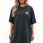 Rear and front view of a woman wearing an oversized breathable cotton t-shirt in charcoal, beige, and brown. The back features a colorful retro graphic of mushrooms and daisies with the text "Love Yourself." The front features a small white minimalist logo on the left chest.