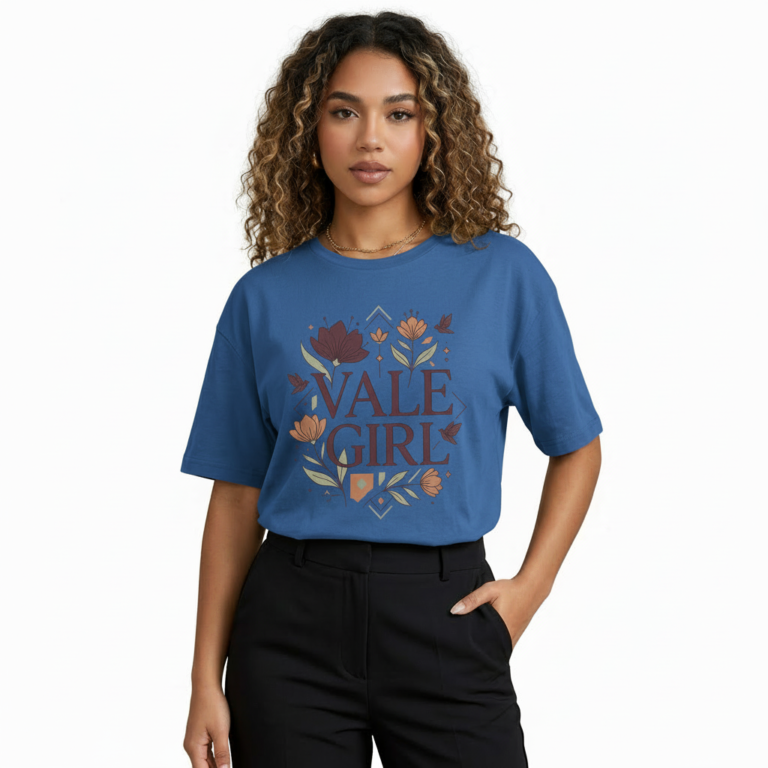 Young woman wearing a "Vale Girl" breathable cotton t-shirt with a vintage floral and hummingbird graphic design, available in Olive Green, Royal Blue, and Red.