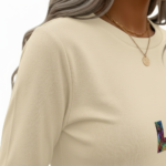 A woman wearing a breathable 3/4 sleeve cotton t-shirt with a colorful vertical "VALE" graphic print, available in cream, red, and black