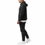 A man wearing a premium breathable cotton tracksuit featuring a colorful watercolor tree graphic with "VALE" text on the back, available in Black, Burgundy, and Sand.