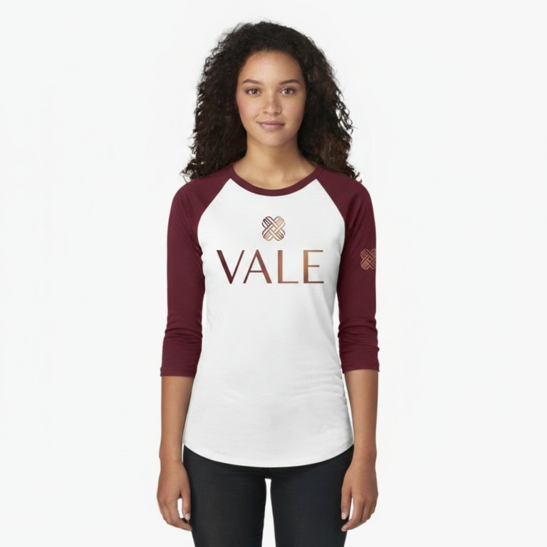 Woman wearing a VALE branded 3/4 sleeve raglan cotton shirt with metallic copper logo, athletic slim fit baseball style.