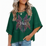 : A person wearing an oversized breathable cotton shirt featuring a "VALE" logo with colorful layered angel wings on the front, available in green, black, and purple.