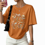 Front view of a woman wearing an oversized breathable cotton t-shirt with a vintage wildflower graphic print, available in blue, green, and orange.