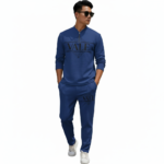 A professional male model wearing a VALE minimalist cotton tracksuit featuring a quarter-zip sweatshirt and matching joggers, isolated on a white background.