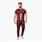 Full-body view of a man wearing the VALE brand breathable cotton activewear set, featuring a vertical logo t-shirt and matching side-striped joggers on a white background.