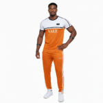 Man wearing VALE brand breathable cotton tracksuit with short-sleeve t-shirt and matching joggers in earth tones.