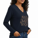 Close-up of a woman wearing a VALE brand long-sleeve V-neck cotton shirt featuring a gold celestial floral graphic design, available in black, navy, and burgundy.