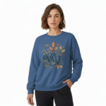Woman wearing a VALE graphic cotton sweatshirt with autumn leaf botanical design, available in Beige, Slate Blue, and Burnt Orange.
