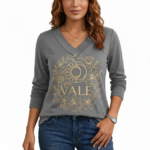 Women's long-sleeve V-neck cotton shirt featuring a gold VALE celestial sun, moon, and floral graphic design.