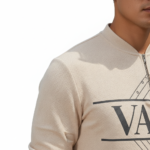 A professional male model wearing a VALE minimalist cotton tracksuit featuring a quarter-zip sweatshirt and matching joggers, isolated on a white background.