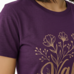 Female model wearing a Vale Limited Edition floral graphic t-shirt made of breathable cotton, featuring copper metallic flower design and script lettering.