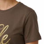 Woman wearing a breathable cotton t-shirt with "Vale" gold script calligraphy design, available in brown, olive green, and maroon.