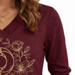 Women's long-sleeve V-neck cotton shirt featuring a gold VALE celestial sun, moon, and floral graphic design.