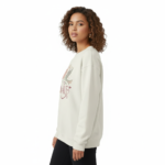 Woman wearing a VALE celestial bird graphic sweatshirt in pink, red, and cream colors. 100% breathable cotton long-sleeve shirt with moon and star design.