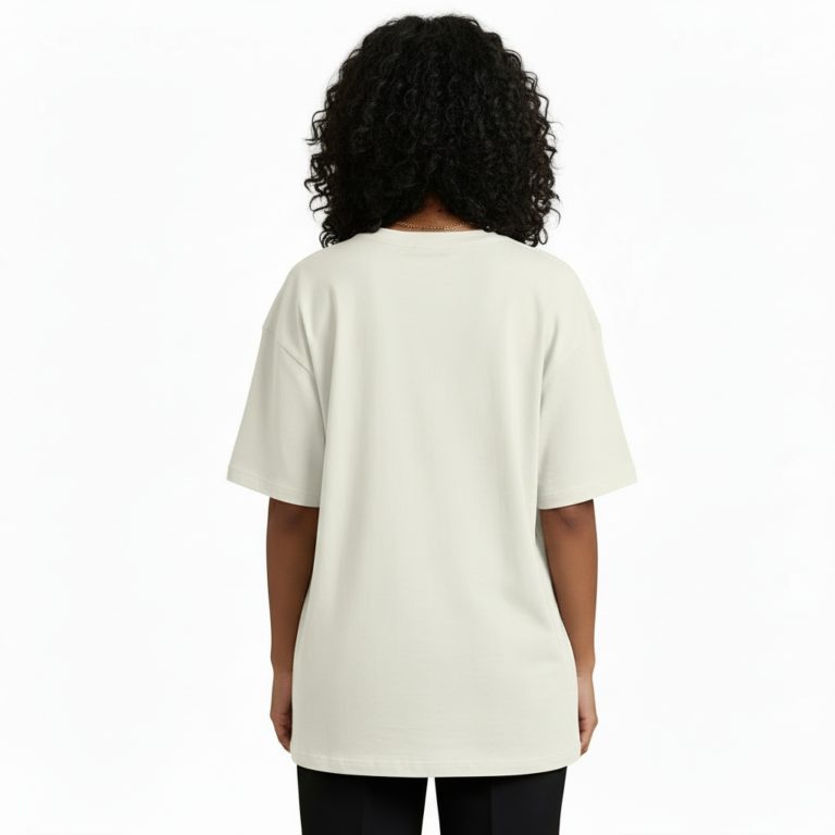 A woman modeling an oversized VALE brand t-shirt featuring a vintage-style Protea flower graphic and celestial symbols. Available in black, grey, and cream colors.