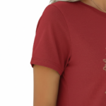 A woman wearing a slim-fit cotton graphic t-shirt featuring the word "VALE" inside a floral wreath design. Available in Dusty Blue, Olive Green, and Deep Maroon colors.