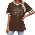 A person wearing a breathable cotton VALE graphic t-shirt with varsity stripes on sleeves, available in black, brown, and orange.