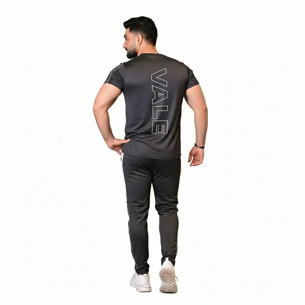 Front and back view of a man wearing the VALE brand breathable cotton performance tracksuit, featuring a vertical outline logo on the t-shirt back and matching side-striped joggers on a white background.